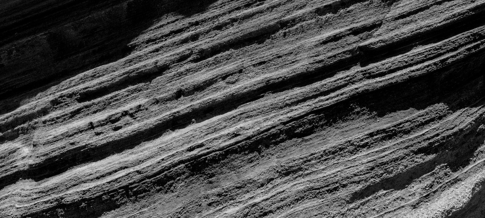 Horizontal bands of layered rock, photographed in black and white