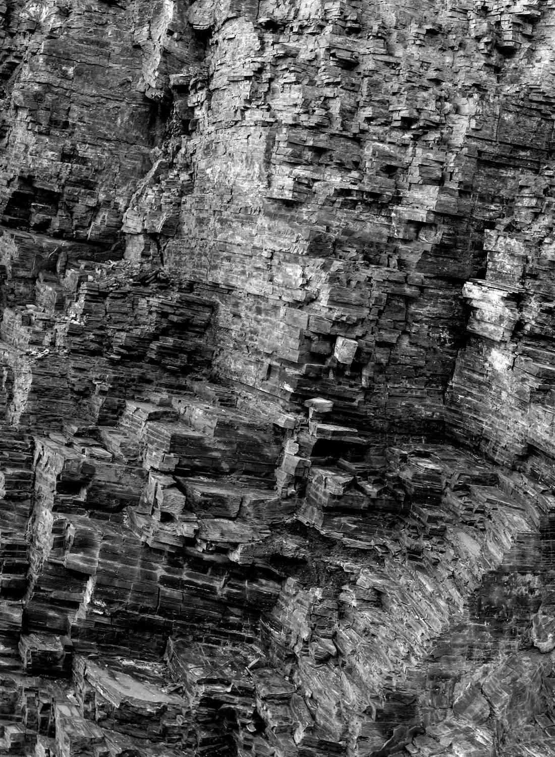 Layered sedimentary rock, photographed in black and white